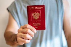 Russian tourist passport in the hand of a citizen. Immigration, legalization, travel concept.