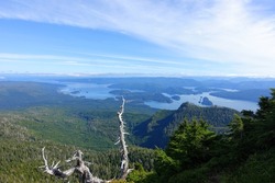 A beautiful view of the scenic ocean and forested mountains from on the top of mount raymond, on the sleeping beauty trail in Haida Gwaii, British Columbia, Canada