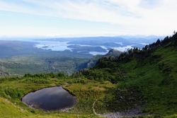 A beautiful view of the scenic ocean and forested mountains from on the top of mount raymond, on the sleeping beauty trail in Haida Gwaii, British Columbia, Canada