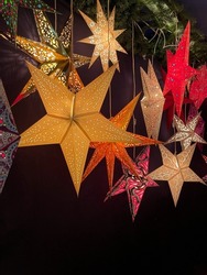 Traditional shining Christmas stars lanterns decorative lamps with open work patten isolated on black background close up