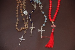 Various Catholic rosary beads with crosses on a dark background