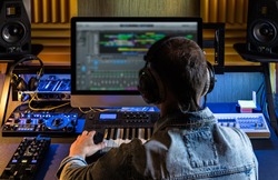 Man produce electronic music in project home recording studio