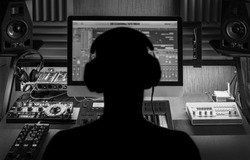 Man produce electronic music in project home recording studio. 
Silhouette. Black and white image.