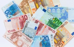 Flat lay of Euro banknotes of different denominations on white background. Concept of payment for services, market relations, loans, economy, inflation, tax. Top view, closeup, mock up