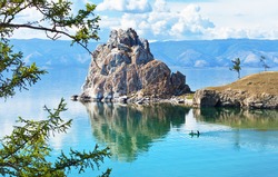  Lake Baikal. Olkhon Island. Tourists sail on a rubber boat near the Shamanka Rock. Summer vacation on the lake