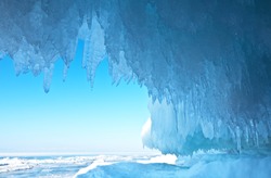 Baikal Lake. Thick blue ice and icicles on the coastal rocks of Olkhon Island in winter. Natural cold background