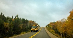 Shool bus on country road in autumn