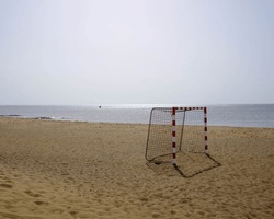 Beach soccer goal with silver sea in the background on a sunny day. Concept