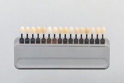 Palette of shades of teeth scale vita. A tool for teeth whitening isolate on a gray background.