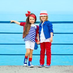 Fashion kids resting on the sea . Vacation, friendship, fashionable concept.