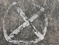 The X symbol is surrounded by a circle drawn from white on a street or a pedestrian. It is an indication that standing, parking, or placing things in the area is strictly prohibited.