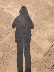 When looking down at the shadow of a woman on a concrete road, the shadow has long legs, a short body. The sunlight that shines through the body creates shadows. That looks funny
