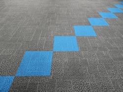 The corridor is covered with gray short-haired carpets and blue carpets interspersed beautifully. The area is patterned with bright blue diamonds.
