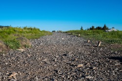 Low Angle of Gravel Covered Trail through grassy field