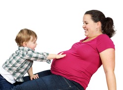 Cute little blond boy touching his pregnant mother's belly