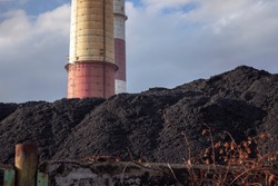 
Coal heap, natural black coal with industrial chimney. Industrial landscape. Global warming, CO2 emission, coal energy issues, energy from fossil fuels, air pollution, climate change. 