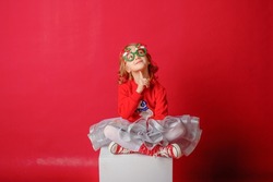little girl on a red background in carnival christmas glasses happy