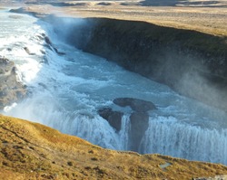 Gullfoss Golden Waterfall in Iceland on a beautiful sunny day in autumn, with a shadow cast by the bank of the river.