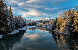 River in the winter forest. Forest river in snowy mountain valley. River in snowy forest. Snowy forest river landscape