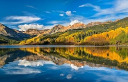 Mountain lake with autumn reflection of trees. Autumn mountain lake landscape. Lake i autumn mountains. Autumn mountain lake view