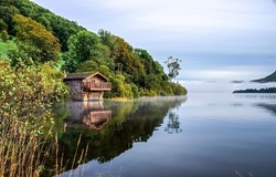 Lake house on the shore of the forest. Lake house view. Landscape of lake house. Lake house in the morning fog