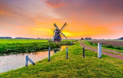 Mill by the river at sunset. Windmill farm at sunset. Beautiful sunset on windmill farm. Windmill at sunset landscape