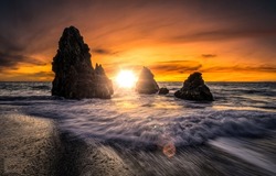 Sunset behind the sea cliffs. Sunset on the beach. Sea rocks at sunset. Seascape at sunset landscape