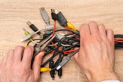 Hands of the master hold wire cutters and bundle of computer cables. Electronics Repair Idea