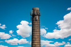 Chimney of a thermal power plant of a boiler room heating against a  sky background. Boiler room, pipe plant, boiler room. Pipe for flue gases from the boiler room. 