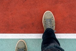 Man stepping over a white line.Walking across the start line representing business and life start up concept. New start, new begining.Top view.
