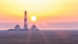Iconic lighthouse of westerhever on North Sea coast of Germany at sunset