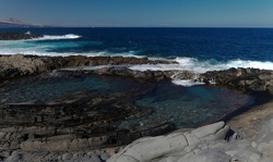 Gran Canaria, north coast, natural swimming pool Charco de Las Palomas protected from the 
ocean waves by rock barrier