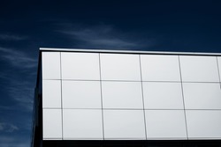 exterior wall of a contemporary commercial style building with aluminum metal composite panels  over sky background