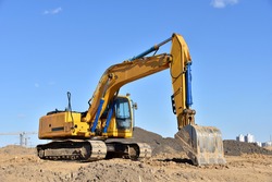 Excavator on earthworks at construction site. Backhoe on foundation work and road construction. Heavy machinery and construction equipment