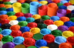 Plastic bottle caps background. Cap material is recyclable.Remove lids from plastic bottles before recycling them. Recycling collection and processing plastic bottle caps