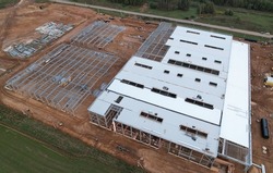 Warehouse Construction from metal structure. Steel Structure Warehouse Building on light gauge steel framing. Aerial view of construction the warehouse from steel structure. Construction site.

