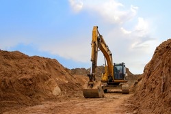 Excavator dig trench at construction site for laying sewer pipes . Backgoe on earthwork. Construction natural gas pipeline. Construction the sewage and drainage. Open pit mining.