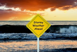 Sign with text 'Stormy Weather Ahead' on the background of the sea with waves. Warning sign about the danger of a storm at sea. Waves at sea during storm and wind. Warning of bad weather and stormy. 