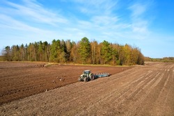 Tractor plowing field. Tractor plow soil cultivating. Cultivated land and soil tillage. Agricultural tractor on farm field cultivation. Tractor disk harrow plowing farm field. Agronomy and agrarian.

