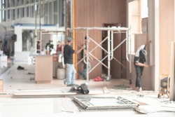 Bokeh image of event setup. Blur image of engineer and backstage crew team working to setting in exhibition hall event. Background image concept.