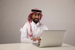 A saudi person sits at his desk