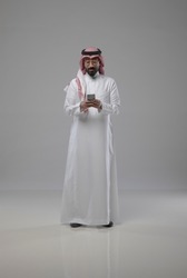 A saudi character holding the phone and looking to the phone on withe background