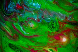 Texture in the style of fluid art. Abstract background with swirling paint effect. Liquid acrylic paint background. Green, blue and red colors.