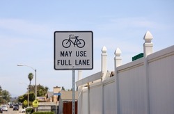 white sign with black text May Use Full Lane.