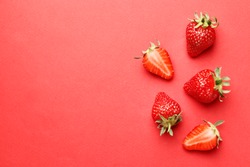 Ripe juicy strawberries on a red background. pattern. Creative summer background composition with strawberry. Minimal fruit concept.