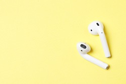 Wireless headphones on a yellow background with place for text.