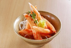 Crab stick or Kani Surimi stick with vegetables decorative in a bowl on wooden background.