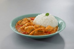 Thai food, Thai chicken red curry with stream rice (panang) in a green plate on grey background.Selective focus.