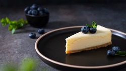 Homemade vanilla cheesecake with blueberry and mint on a dark background - healthy organic summer dessert pie cheesecake. Cheesecake New York. Side view, close up. Menu, recipe, confectionery