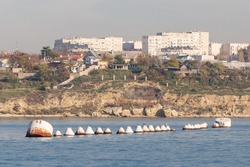 A row of large iron barrels for mooring ships. Buoys on the background of the city of Sevastopol inside the bay.